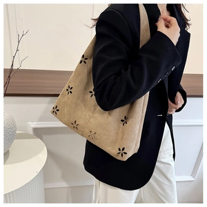 Detail of laser-cut flower patterns on khaki suede tote bag for women commuting