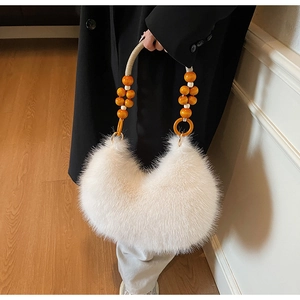 Détail du sac hobo en fausse fourrure blanche avec poignée en perles ambre et cordons