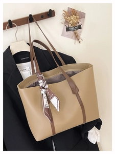 Detail of khaki tote bag with brown straps and stylish floral silk scarf accessory
