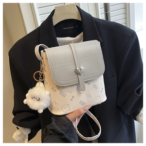 Close-up of beige crossbody bucket bag with cat prints and a heart-shaped metal lock