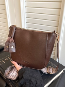 Modieuze donkerbruine crossbodytas met brede geometrische riem en gouden metalen details