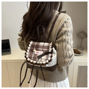 Detailed back view of a Japanese style backpack with lace ruffles and a brown ribbon bow