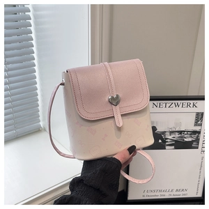 Detail of pink and beige bucket bag with cat pattern and silver heart-shaped metal clasp