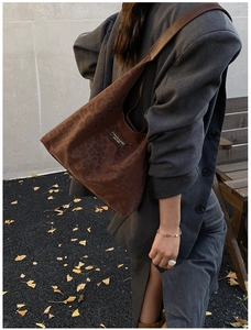 Close-up of stylish brown leopard print hobo bag worn with a casual gray blazer suit