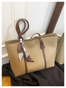 Detail of apricot tote bag with large capacity, brown handles and printed silk scarf