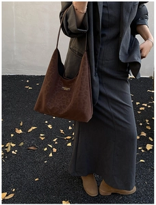 Close-up of leopard print tote bag with soft suede texture and black fashion logo plaque