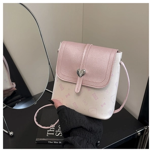 Detail of light pink crossbody bag with cat prints and heart-shaped silver metal buckle