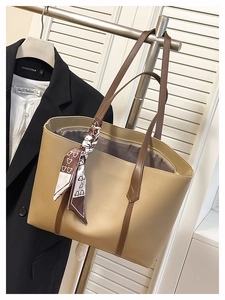 Detail of a large khaki tote bag with a decorative heart-print scarf and inner pocket