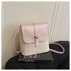Detail of pink and white bucket bag with silver heart buckle and bow print textures