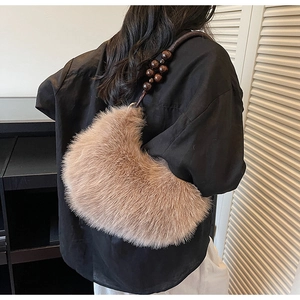 Détail du sac à bandoulière en peluche marron avec sangle en perles de bois et texture douce
