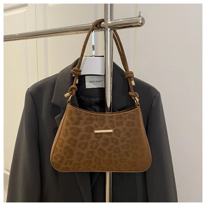 Détail du sac léopard en daim avec garniture dorée et bandoulière à nœuds sophistiquée