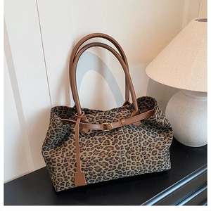 Close-up of leopard print suede tote bag with leather strap and decorative hangtag