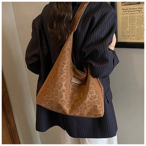 Detail of vintage leopard print tote bag with leather logo tag and wide shoulder strap