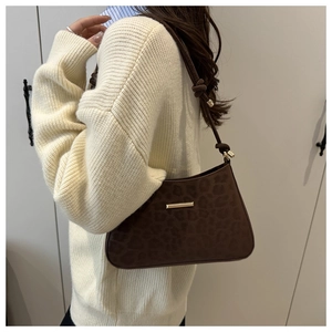 Détail du sac léopard avec boucles dorées et bandoulière aux finitions nouées chic