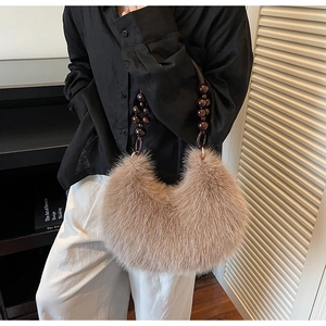 Détail du sac croissant en peluche avec anse ronde en perles de bois et fausse fourrure