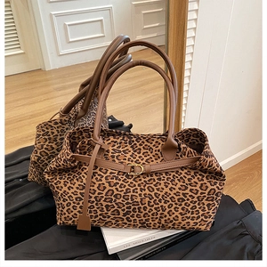 Detail of leopard print tote bag featuring brown faux suede and gold buckle hardware