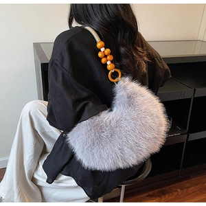 Détail du sac bandoulière en fausse fourrure grise avec bandoulière perlée et texture douce