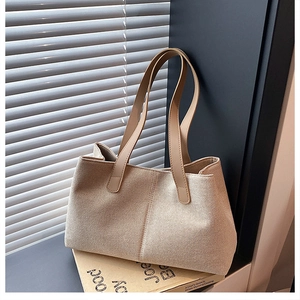 Detailed view of beige canvas tote bag with woven fabric texture and sleek shoulder strap