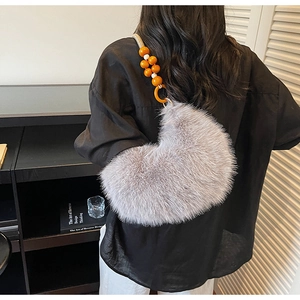 Sac bandoulière en peluche grise avec anse perlée orange et forme demi-lune