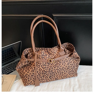 Detailed shot of leopard print tote bag with brown PU straps on a white desk