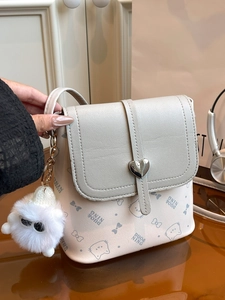 Cream crossbody bucket bag with heart buckle, cat prints and fuzzy monster charm
