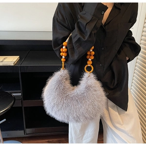 Vue détaillée du sac à main en fausse fourrure grise avec anse en perles orange