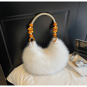 Détail du sac hobo en fausse fourrure blanche avec anse tressée et perles jaunes