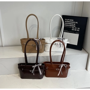 Borse tote minimaliste in ecopelle in quattro colori su gradini di marmo con nastri seta