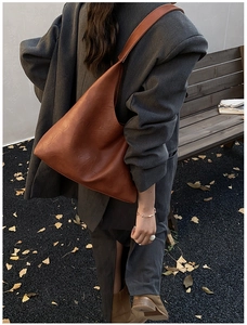 Brown leather hobo tote bag shown on model for autumn commute style in outdoor city setting