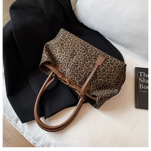 Detail of leopard print tote bag with brown leather strap and golden buckle buckle