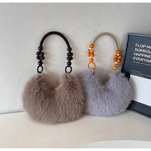 Détail de sacs à bandoulière en peluche marron et gris avec anses en perles de bois