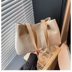 Detail of canvas tote bag with brown faux leather straps and large interior capacity