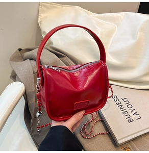 Vue détaillée du sac à main rouge en cuir ciré brillant avec bandoulière en chaîne