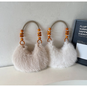 Détail de sacs à main en fausse fourrure avec anses en corde et perles de bois