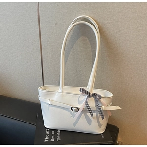 Dettaglio borsa tote in pelle bianca con fiocco a scacchi bianco e nero e cinturino