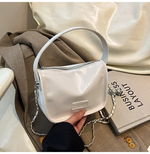 Détail du sac à main blanc en cuir avec étiquette Fashion et chaîne argentée