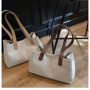Close-up of retro canvas tote bags with leather straps on a vintage wooden floor