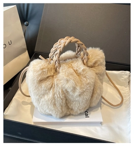 Detail of soft beige faux fur handbag with brown woven leather handle in a gift box