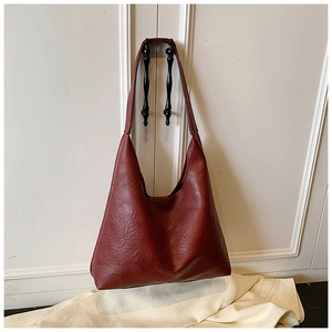 Close-up of vintage burgundy large tote bag with textured faux leather and wide strap