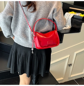 Détail du sac bandoulière rouge avec bandoulière chaîne et plaque Fashion