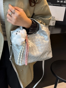 Silver woven crossbody bag with plush charm and adjustable strap for women