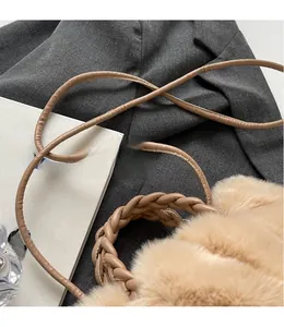 Close-up of khaki plush shoulder bag with woven handle and slim strap detail