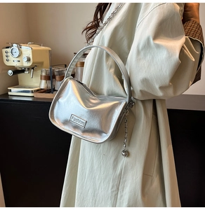 Détail du sac hobo argenté avec bandoulière chaîne et plaque logo Fashion gravée