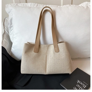 Detail of minimalist cream canvas tote bag with leather straps on a modern aesthetic background