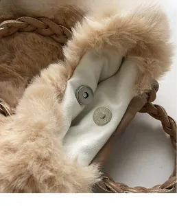 Detail of magnetic silver buckle and soft faux fur texture on brown handbag