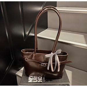 Dettaglio borsa tote marrone vintage in ecopelle con fibbia metallica e fiocco a scacchi
