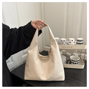 Detail of off-white lychee texture tote bag with integrated handle and large capacity