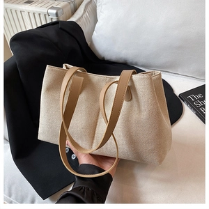 Detailed texture of beige canvas tote bag with brown leather handle in lifestyle setting