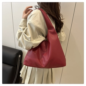Detailed view of red pebble leather tote bag worn on shoulder for business and daily commute