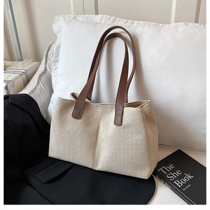 Detail of beige canvas tote bag with premium brown leather straps on office commute background